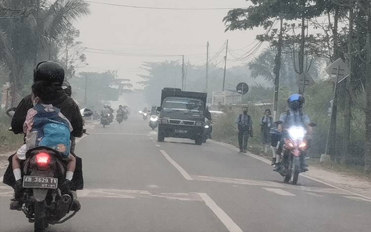 Kabut asap menyelimuti Kota Palangka Raya di jam keberangkatan anak-anak sekolah pada Rabu, 27 September 2023.(FOTO: TESTI PRISCILLA)