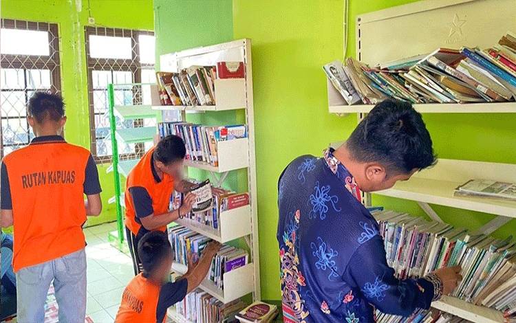Petugas Rutan Kapuas saat ajak WBP baca buku di perpustakaan Rutan setempat. (FOTO: IST)