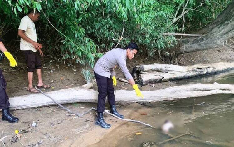Salah satu anggota Polres Lamandau menunjukkan lokasi penemuan bayi yang mengapung di Sungai Lamandau. (FOTO : HENDI NURFALAH)