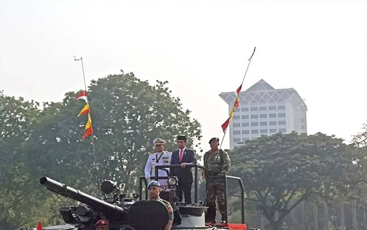 Presiden Joko Widodo menaiki tank untuk memeriksa pasukan upacara dalam HUT ke-78 TNI di Monumen Nasional, Jakarta, Kamis (5/10/2023). (ANTARA/Indra Arief Pribadi)