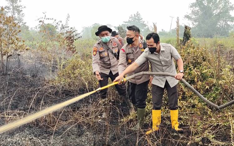 Ketua DPRD Pulang Pisau, H.Ahmad Rifai bersama dengan jajaran Polres Pulang Pisau saat memadamkan titik api di Desa Tanjung Taruna Jum'at Kemarin. (FOTO : IST)