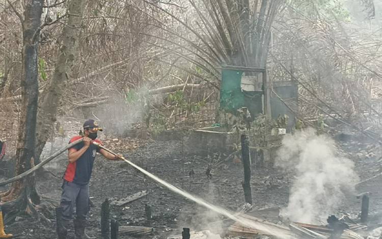 Anggota DPKP Palangka Raya saat melakukan pendinginan di lokasi pondok kosong terbakar. (FOTO: DPKP Palangka Raya)