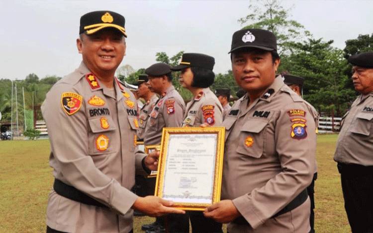 Kapolres Lamandau AKBP Bronto Budiyono memberikan penghargaan kepada salah satu personel berprestasi. (FOTO : HENDI NURFALAH)