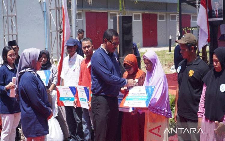 Penjabat Gubernur Jawa Tengah Nana Sudjana menyerahkan bantuan atensi dan paket sembako pada penerima manfaat yang diselenggarakan di Kawasan Industri Terpadu Kabupaten Batang, Senin (9/10/2023). (ANTARA/Kutnadi)