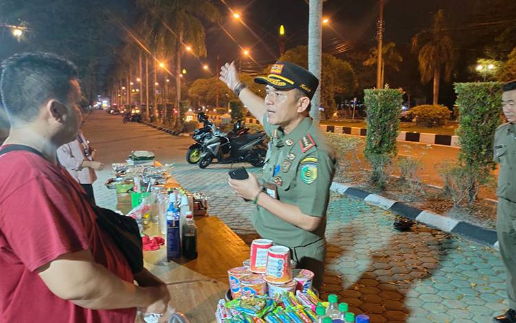 Satpol PP Palangka Raya saat sosialisasi kepada PKL Taman Yos Sudarso agar pindah ke Pasar Datah Manuah. (FOTO: HENDRI)
