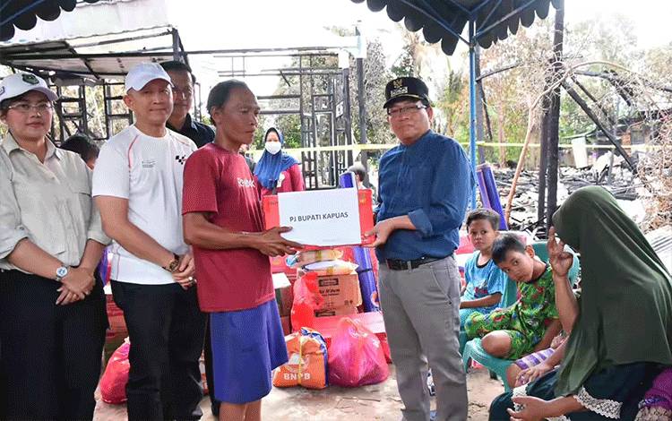 Pj Bupati Kapuas, Erlin Hardi saat serahkan bantuan kepada warga terdampak kebakaran kebakaran rumah di Kelurahan Palingkau Lama. (FOTO: IST)