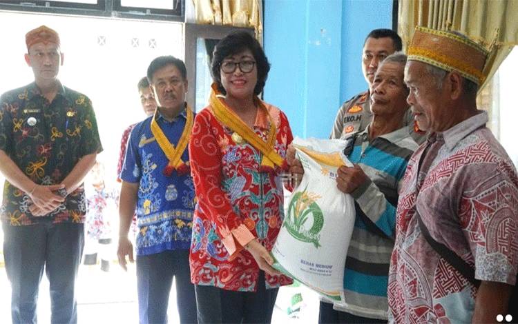Pj Bupati Lamandau Lilis Suriani menyalurkanbantuan pangaoCBP Tahap II bagi KPM di Kecamatan Delang. (FOTO : HENDI NURFALAH)