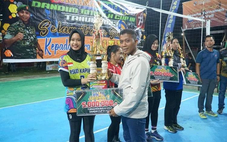Dandim 1011 Kuala Kapuas, Letkol Inf Khusnun Dwi Putranto saat serahkan piala kepada juara turnamen voli putri. (Foto: IST)