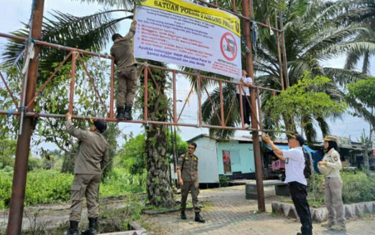 Petgas Satpol PP memasang spanduk larangan untuk pedagang di kawasan Bundaran Balanga.