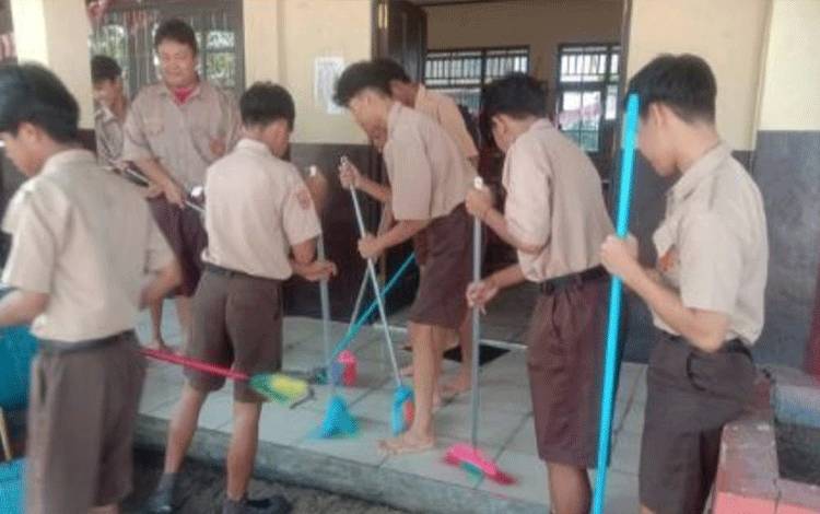 Aksi bersih-bersih kalangan pelajar dalam gerakan pemberantasan sarang nyamuk. (FOTO: HENDRI)