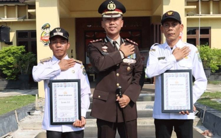 Kapolres Kapuas, AKBP Kurniawan Hartono saat serahkan penghargaan kepada dua Kades pada Sabtu, 28 Oktober 2023. (FOTO: IST)
