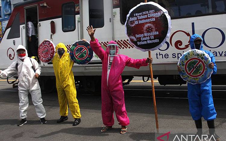 Ilustrasi - Relawan memakai pakaian hazmat dan mengusung poster untuk memperingati Setahun Pandemi COVID-19 di Indonesia saat aksi di Jalan Gatot Subroto, Solo, Jawa Tengah, Selasa (2/3/2021). ANTARA FOTO/Maulana Surya/foc/pri.