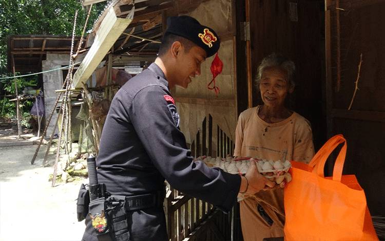 Personel Satbrimobda Kalteng saat memberikan paket sembako kepada lansia (Foto : Satbrimobda Kalteng)