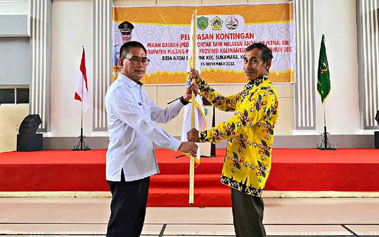 Sekretaris Daerah Pulang Pisau, Tony Harisinta saat menyerahkan bendera kontingen Pulang Pisau PEDA KTNA XIII. Rabu, 15 November 2023. (FOTO : M PRADILA KANDI)