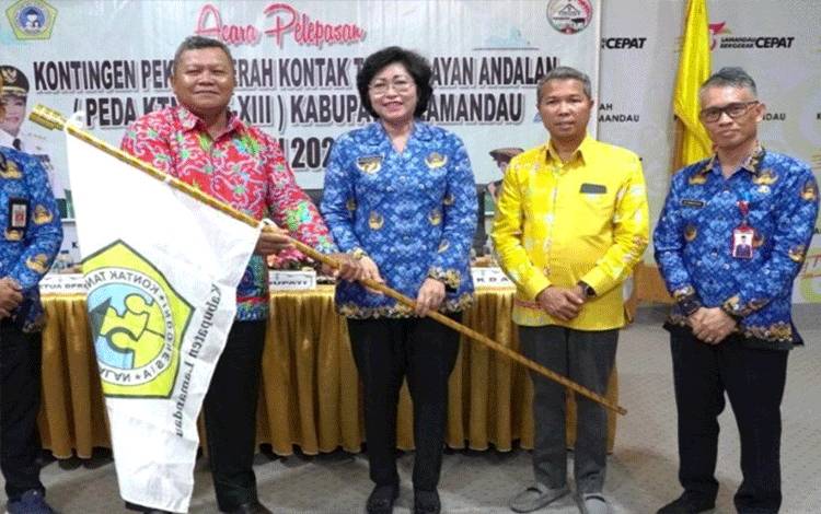 Penjabat Bupati Lamandau Lilis Suriani menyerahkan pataka KTNA Kabupaten Lamandau kepada ketua rombongan kontingen Peda. (FOTO : HENDI NURFALAH)