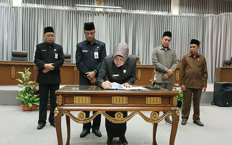Ketua DPRD Barito Utara, Hj Mery Rukaini saat menandatangani berita acara persetujuan bersama dua buah Raperda untuk dijadikan Perda.(foto: Dhani) 