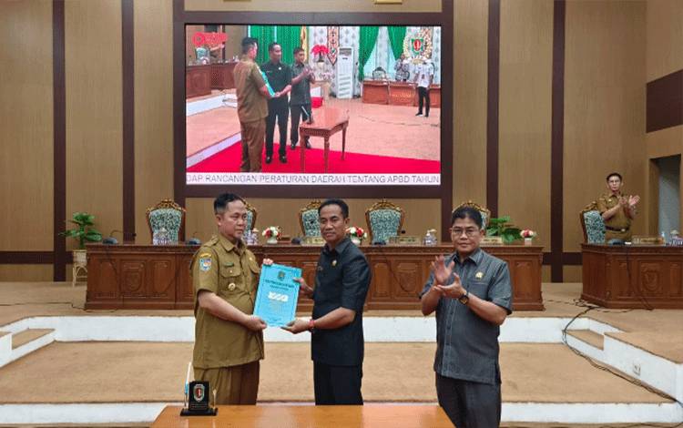 Pj Bupati Katingan Saiful dan Ketua DPRD Marwan Susanto serta Wakil Ketua DPRD Nanang Suriansyah foto bersama dengan memperlihatkan dokumen RAPBD tahun anggaran 2024 yang telah disepakati bersama menjadi sebuah peraturan daerah (Perda).