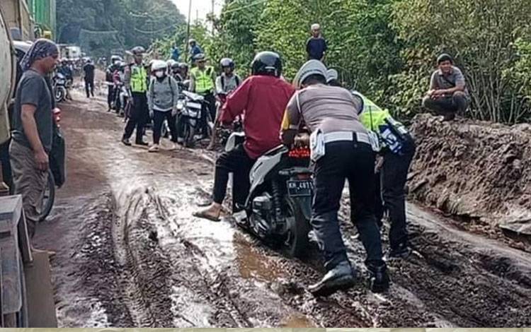Personel Saltlantas Polres Katingan membantu pengendara terutama roda dua yang terjebak di ruas Jalan Trans Kalimantan arah Kasongan - Kereng Pangi yang dalam perbaikan.