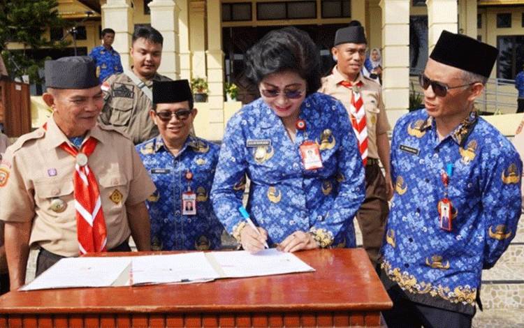 Penjabat Bupati Lamandau Lilis Suriani menandatangani naskah hibah mobil operasional Kwartir Cabang Lamandau. (FOTO : HENDI NURFALAH)