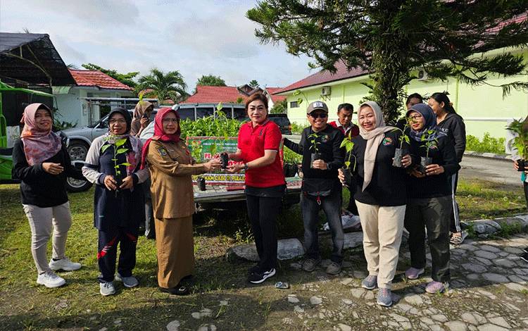 Kadis TPHP Provinsi Kalteng, Sunarti menyerahkan bibit gratis kepada salah satu pengunjung Pasar Tani. (FOTO: IST)