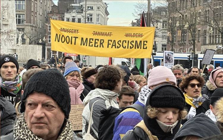 Pengunjuk rasa membawa spanduk bertuliskan "Nooit meer fascisme" yang berarti "jangan pernah lagi fasisme" saat memprotes Geert Wilders. (ANTARA/Anadolu Ajansi)