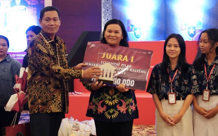 Staf Ahli Gubernur Kalteng Bidang Ekonomi, Keuangan dan Pembangunan Yuas Elko saat menyerahkan penghargaan kepada pemenang lomba. (FOTO: DEDE)