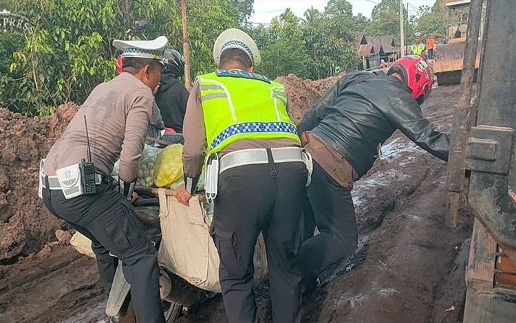 Pihak Kepolisian saat membantu masyarakat, saat melewati perbaikan jalan di wilayah Kabupaten Katingan. (Foto:Istimewa)