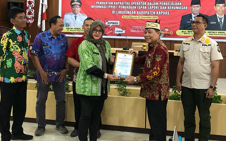Plt Kepala Disdukcapil Kapuas, Sipie S Bungai saat menerima penghargaan OPD responsif tindaklanjuti SP4N LAPOR, bertempat di Aula Bappelitbangda setempat. (FOTO: IST)