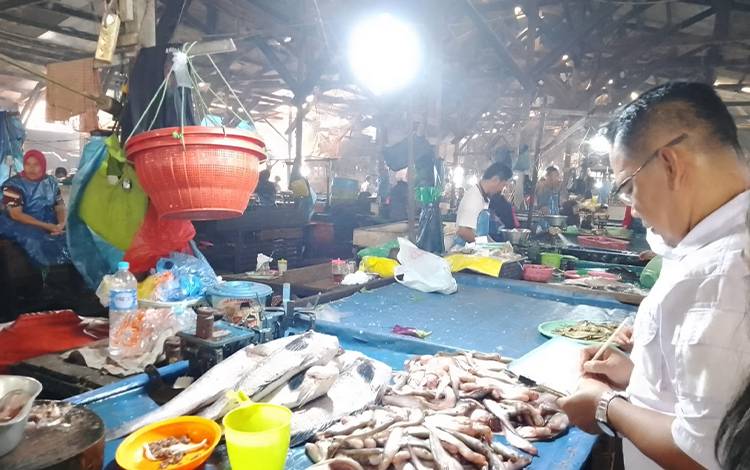 Sekretaris Dinas Perikanan Palangka Raya Sri Utomo saat melakukan survei harga ikan di Pasar Besar. (FOTO: PATHUR)