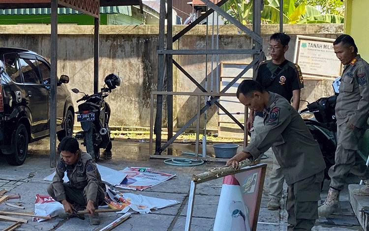 Personel Satpol PP dan Damkar Kapuas saat lakukan kurve dan bersihkan kayu bekas spanduk di halaman kantor. (FOTO: IST)