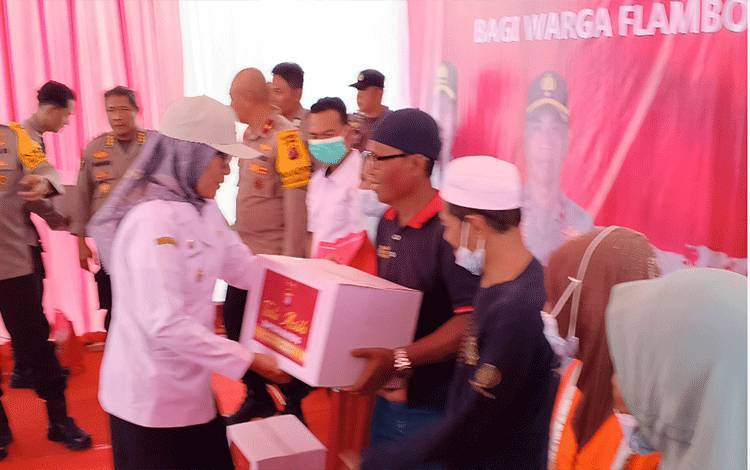 Pj Wali Kota Palangka Raya, Hera Nugrahayu memberikan bantuan kepada warga Flamboyan Bawah. (FOTO: HENDRI)