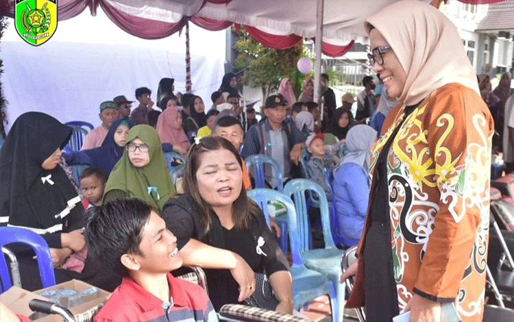 Pj Wali Kota Palangka Raya, Hera Nugrahayu berbincang dengan penyandang disabilitas saat peringatan HDI. (FOTO: HUMAS)