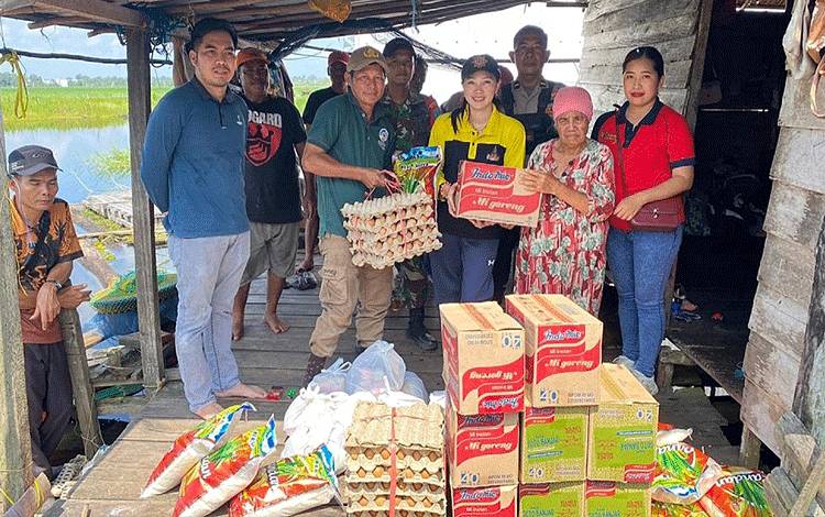 Camat Karusen Janang Bewini didampingi anggota TNI dan Polri saat menyerahkan bantuan Pemky Barito Timur untuk warga terdampak banjir di Desa Dayu dan Wuran, Jumat, 22 Desember 2023. (FOTO: IST)