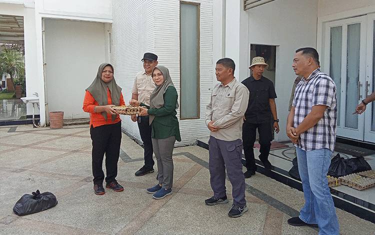 Pj Bupati Pulang PisauNunu Andriani didampingi Kadis DLH, Kadis Kominfo dan Kalaksa BPBD saat menyerahkan sembako untuk petugas kebersihan. Sabtu, 23 Desember 2023. (FOTO : M PRADILA KANDI)
