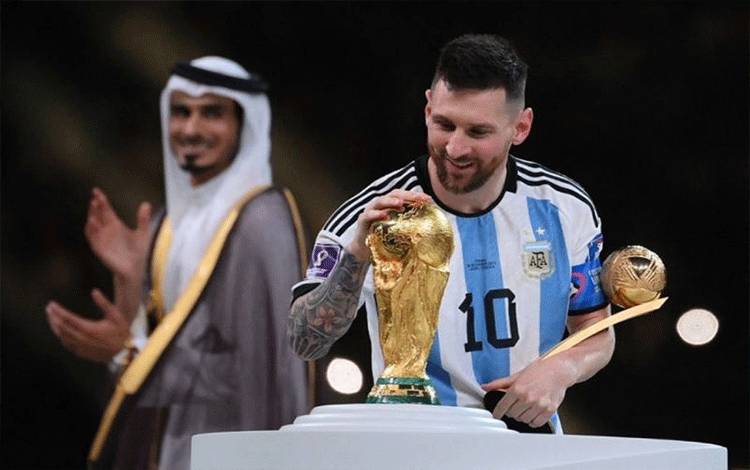 Arsip - Mega bintang Argentina Lionel Messi menyentuh trofi Piala Dunia setelah menerima anugerah Pemain Terbaik di Piala Dunia 2022 Qatar pada 18 Desember 2022. (Photo by (FRANCK FIFE / AFP) (AFP/FRANCK FIFE)