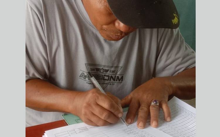 Seorang nelayan mengisi dokumen ke-pelautan. (FOTO: ISTIMEWA)