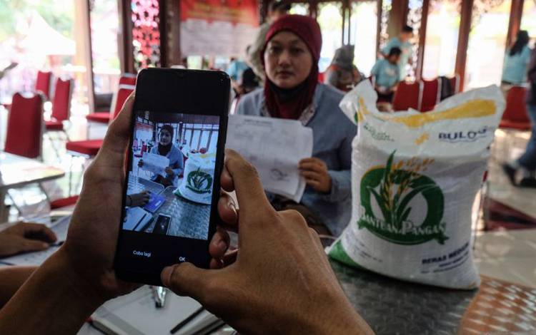 Petugas memotret data warga penerima manfaat bantuan pangan beras dari pemerintah di Kelurahan Nusukan, Solo, Jawa Tengah. ANTARAFOTO/Maulana Surya/foc. (ANTARA FOTO/Maulana Surya)