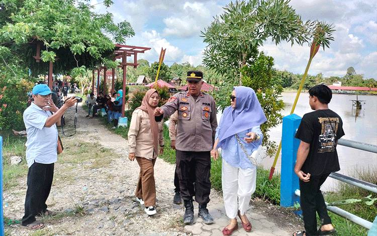 Kepala Disbudparpora Barito Utara, Hj Annisa Cahyawati bersama pihak kepolisian dan pemerintah Desa saat meninjau salah satu objek wisata DAM Trinsing, Senin, 1 Januari 2024. (Foto: Dhani)