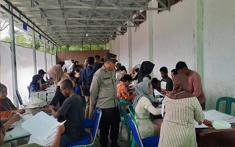 Petugas kepolisian saat melakukan pengawasan penyortiran dan pelipatan surat suara pemilu di KPU Kobar. (Foto : DANANG)