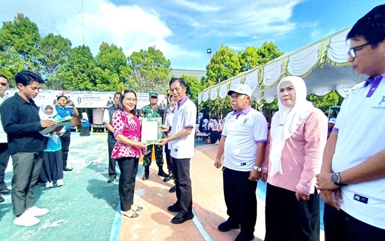 Pj Bupati Barito Utara Drs Muhlis menyerahkan sertifikat halal dari Kementerian Agama kepada para pelaku usaha UMKM di daerah setempat, usai peringatan HAB ke 78 di halaman MTsN Barito Utara, Rabu 3 Januari 2024. (Foto: Dhani)