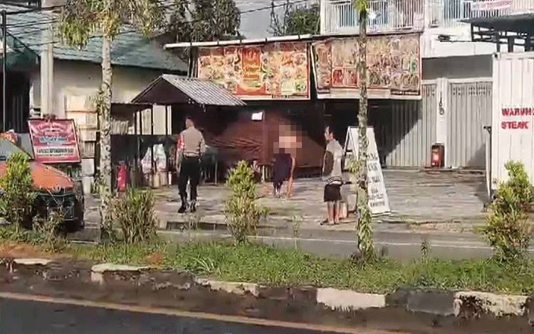 Tangkapan layar video Polisi saat akan mengamankan dua orang yang diduga depresi dan berbuat tak senonoh di pinggir jalan A Yani, Pangkalan Bun. (FOTO: DANANG)