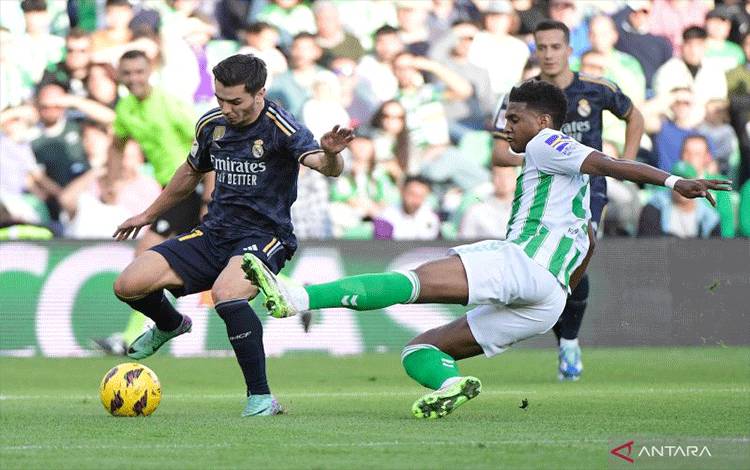 Real Madrid's Spanish forward #21 Brahim Diaz (L) fights for the ball with Real Betis' Moroccan defender #28 Chadi Riad during the Spanish league football match between Real Betis and Real Madrid CF at the Benito Villamarin stadium in Seville on December 9, 2023. (Photo by CRISTINA QUICLER / AFP) (AFP/CRISTINA QUICLER)