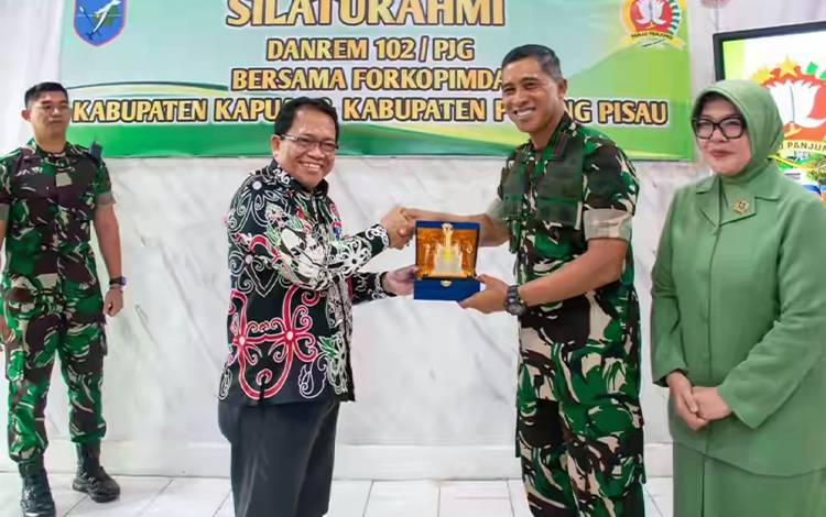 Pj Bupati Kapuas Erlin Hardi saat memberikan plakat kepada Brigjen TNI Iwan Rosandriyanto, bertempat di Mako Kodim Kuala Kapuas. (FOTO: IST)