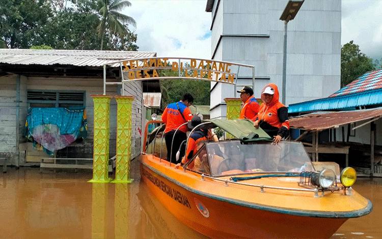 Kepala Pelaksana BPBD Kapuas, Panahatan Sinaga bersama jajaran lakukan pengecekan kondisi banjir di Desa Lapetan, Kecamatan Mantangai, kemarin. (FOTO: IST)