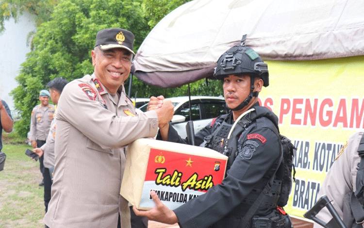 Wakapolda Kalteng Brigjen Pol Mohamad Agung Boedijono menyerahkan tali asih pada personel yang bertugas di objek vital KPU Kobar. (Foto : ISTIMEWA)