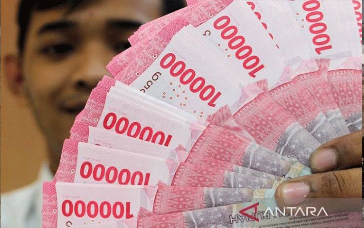 Ilsutrasi - Petugas bank menunjukkan lembaran uang rupiah di salah satu bank di Jakarta. (ANTARA FOTO/Putu Indah Savitri/sgd/YU/am.)