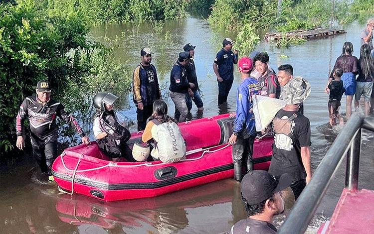 Relawan gabungan dari Barito Timur membantu menyebarkan orang maupun barang di lokasi banjir jalan provinsi Desa Lembeng Kabupaten Barito Selatan, Selasa, 22 Januari 2024. (FOTO: IST)