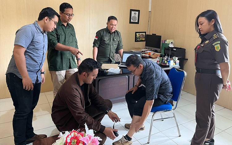 Penyidik Kejaksaan Negeri Seruyan saat melakukan pemasangan alat detection kit kepada tersangka Syang berstatus sebagai tahanan kota (Foto: KEJARI SERUYAN)