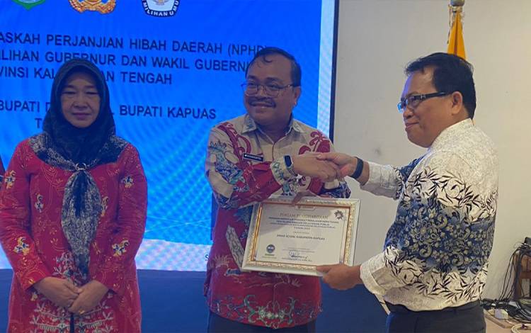 Pj Bupati Kapuas, Erlin Hardi saat serahkan piagam penghargaan kepada Kepala Dinsos Kapuas, Yanmarto, Kamis, 25 Januari 2024. (FOTO: IST)