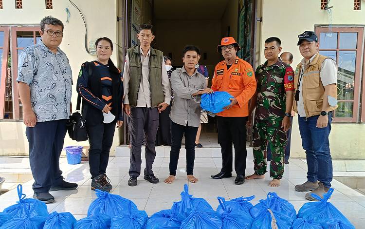 Kalaksa BPBD Damkar Barito Timur menyerahkan bantuan bahan kebutuhan pokok secara simbolis untuk warga terdampak banjir di Desa Telang Baru Kecamatan Paju Epat, Kamis, 25 Januari 2024. (FOTO: BOLE MALO)
